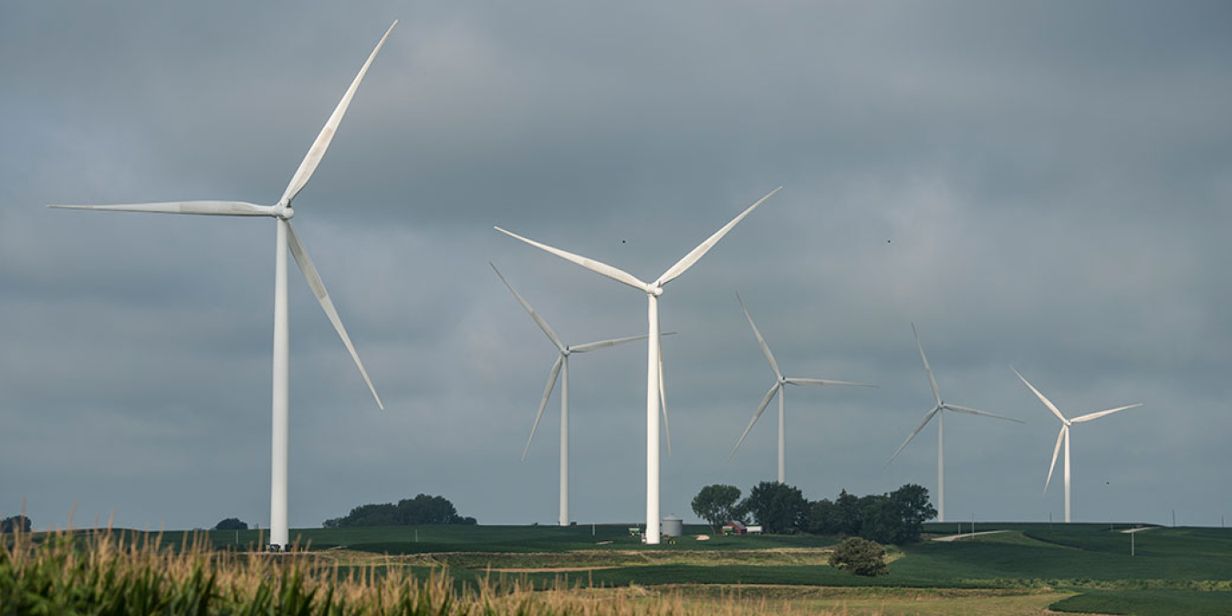 Land-based wind turbines against a cloudy sky.