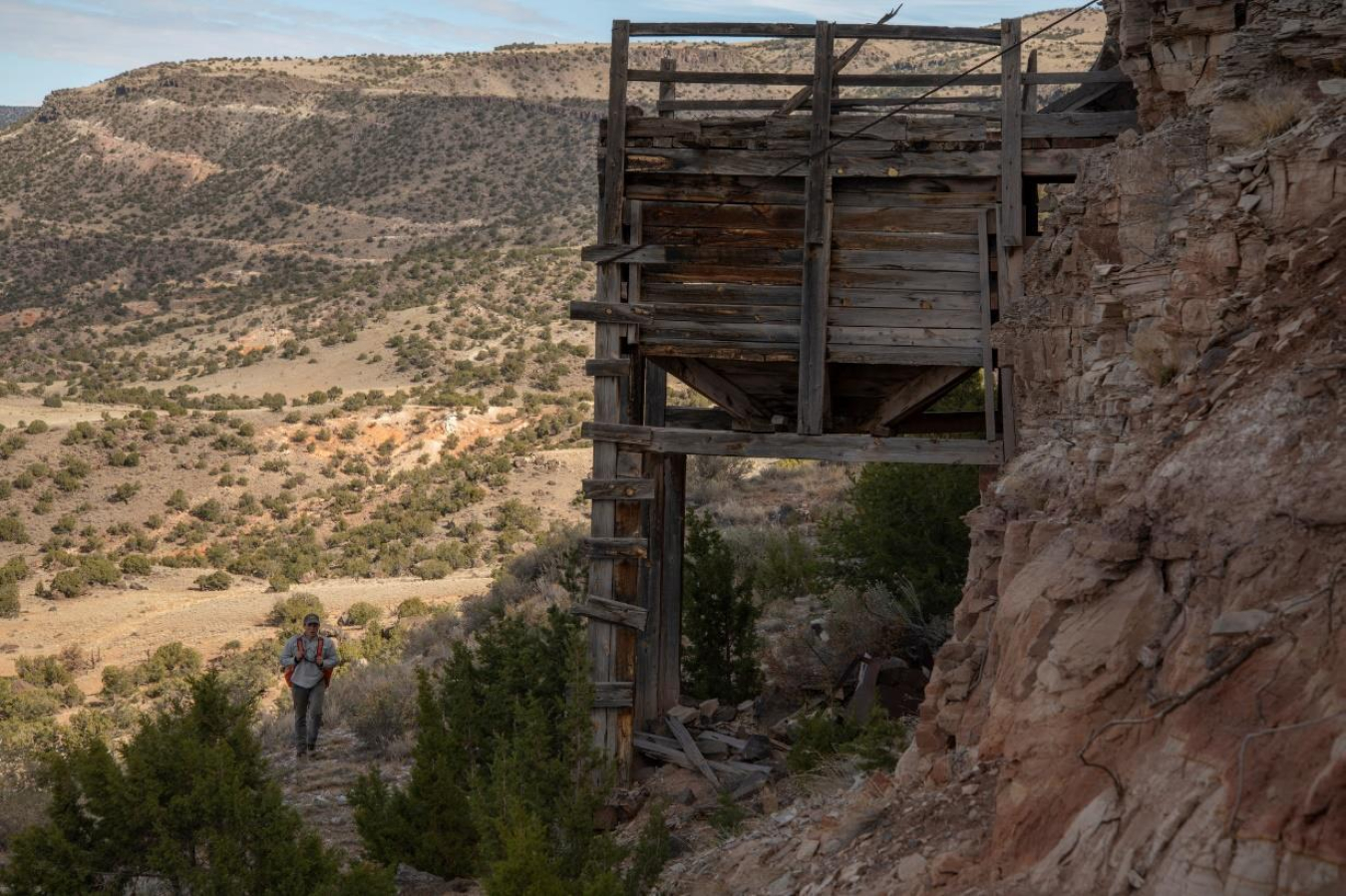 A staff member from Bat Conservation International walks below a wooden ore bin in New Mexico.  (Photo by Bill Hatcher/BCI.)