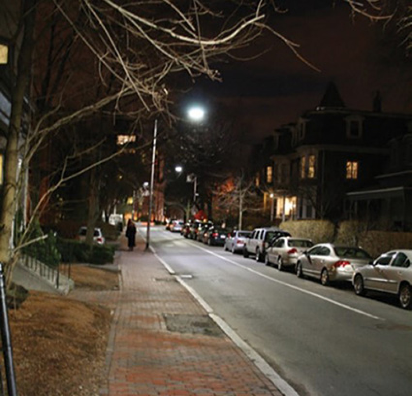 A city street at night with a lighted streetlight.