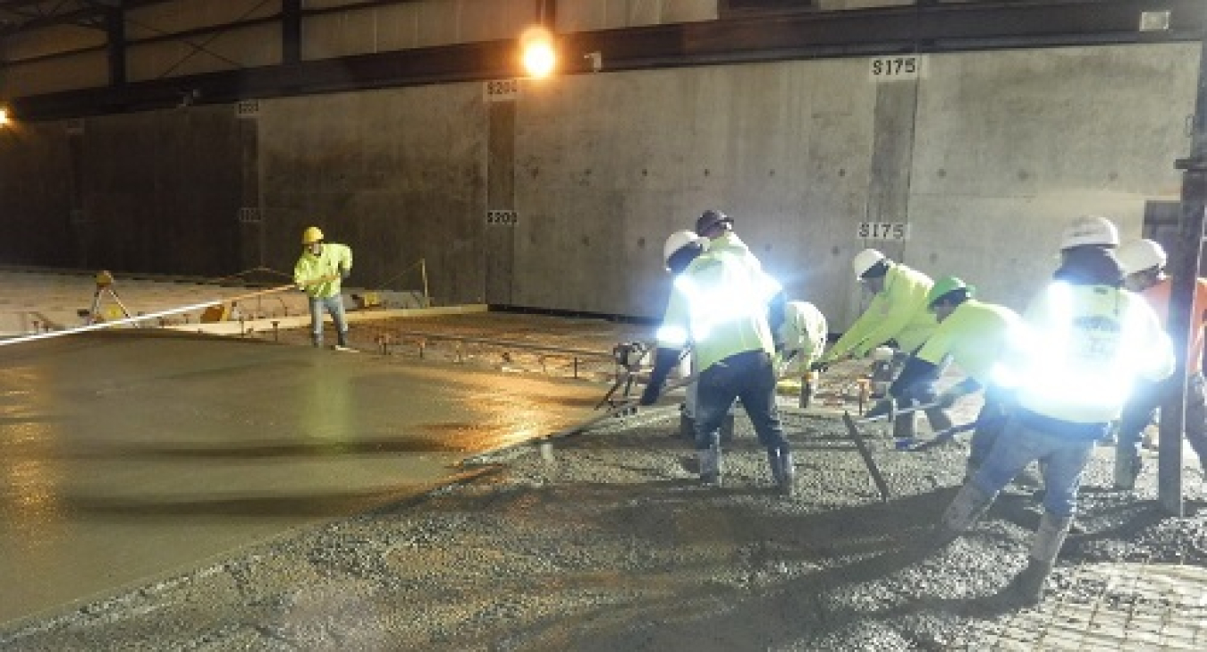 Workers at the West Valley Demonstration Project place concrete for a new floor inside a former storage facility.