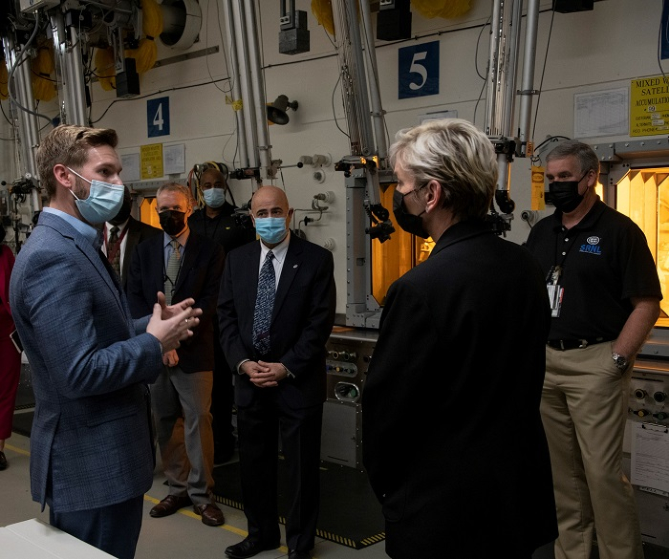 Energy Secretary Jennifer Granholm speaks with Harris Eldridge with Savannah River National Laboratory (SRNL), at left, while on a tour of the shielded cells facility at SRNL. 