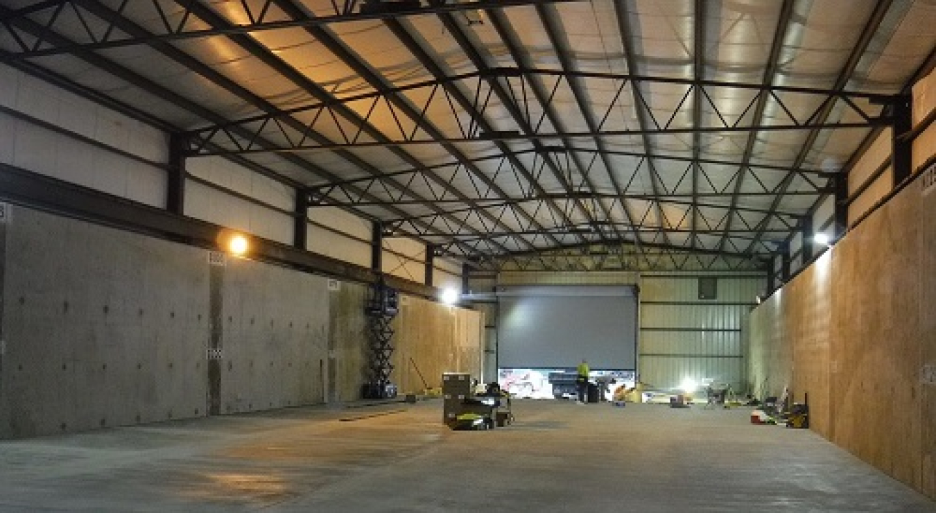 Crews renovate a former storage facility for waste disposal operations at the West Valley Demonstration Project. A new roll-up door is in the background.