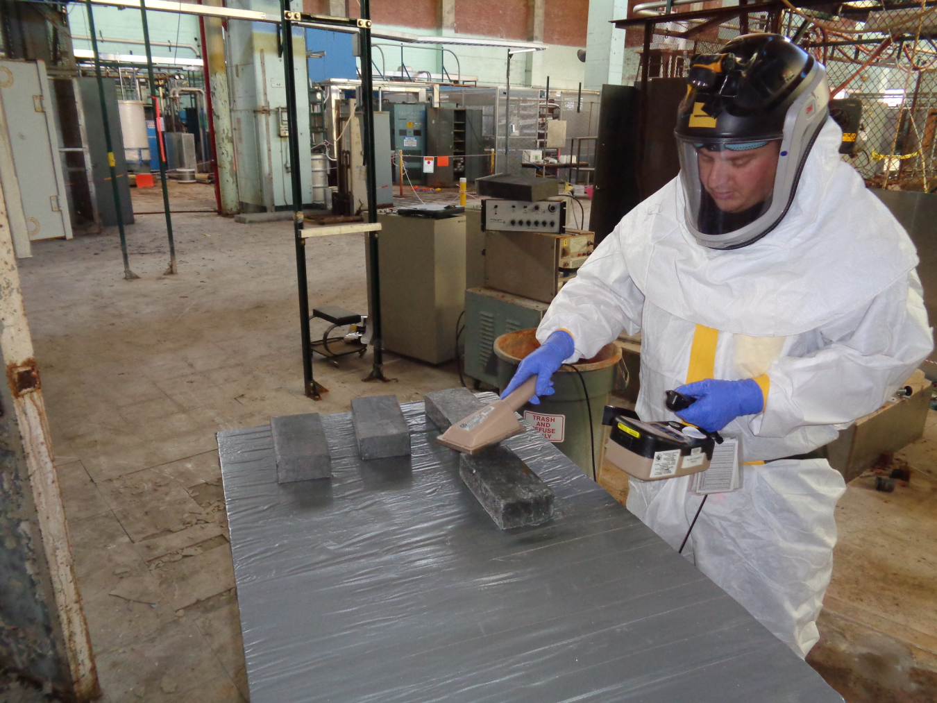 A worker surveys and inspects lead bricks in the Alpha-2 facility at Oak Ridge. Crews will remove approximately 750,000 pounds of lead shielding blocks from the facility during deactivation.