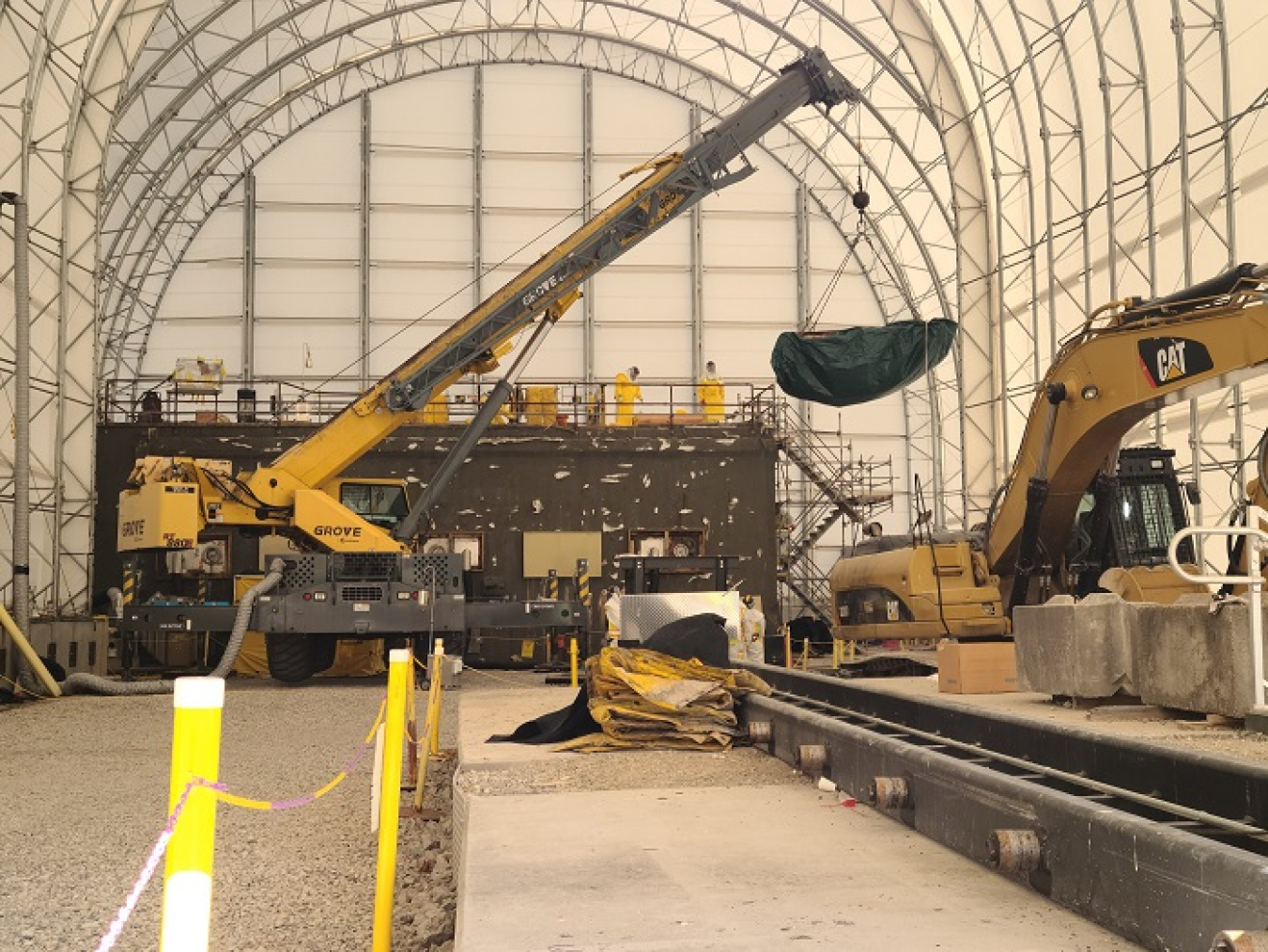 EM crews used an 80-ton crane to lift a 9,000-pound concrete plug atop the roof of the East Cell Bank at Oak Ridge National Laboratory, providing access to send detection equipment into the structure to get readings for characterization.