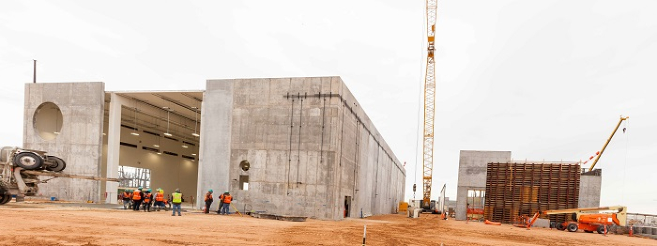 At left, workers pour a concrete access ramp at the Waste Isolation Pilot Plant’s (WIPP) 25,000-square-foot Salt Reduction Building while cranes lift concrete for wall construction on the 55,000-square-foot New Filter Building, right. Together, the two buildings make up the Safety Significant Confinement Ventilation System that, when finished, will increase airflow in the WIPP underground from 170,000 cubic feet per minute to 540,000 cubic feet per minute.