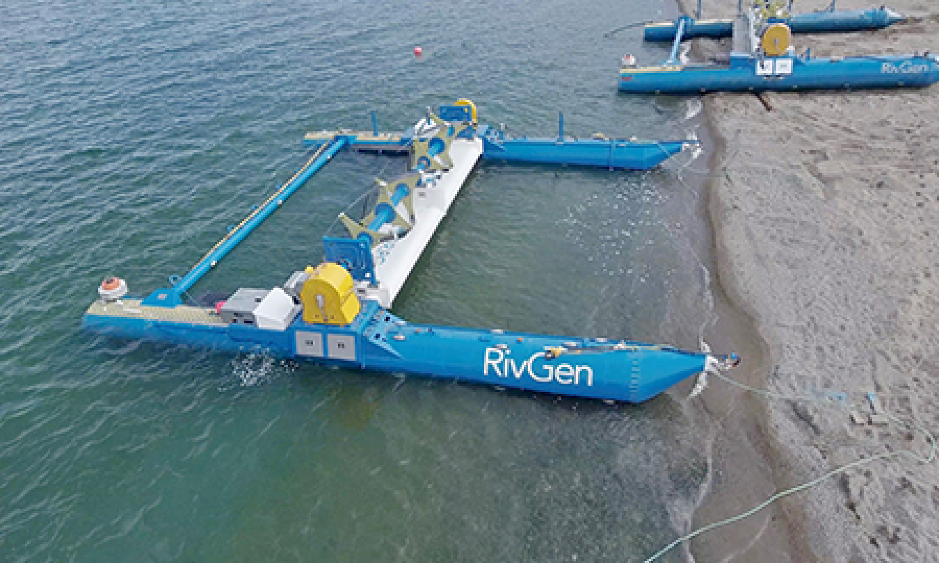 Aerial photo of two tidal turbines on the bank of a river.