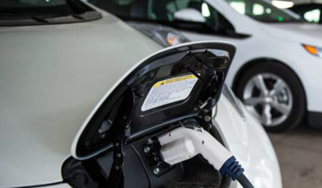 White electric vehicle plugged into a charging station