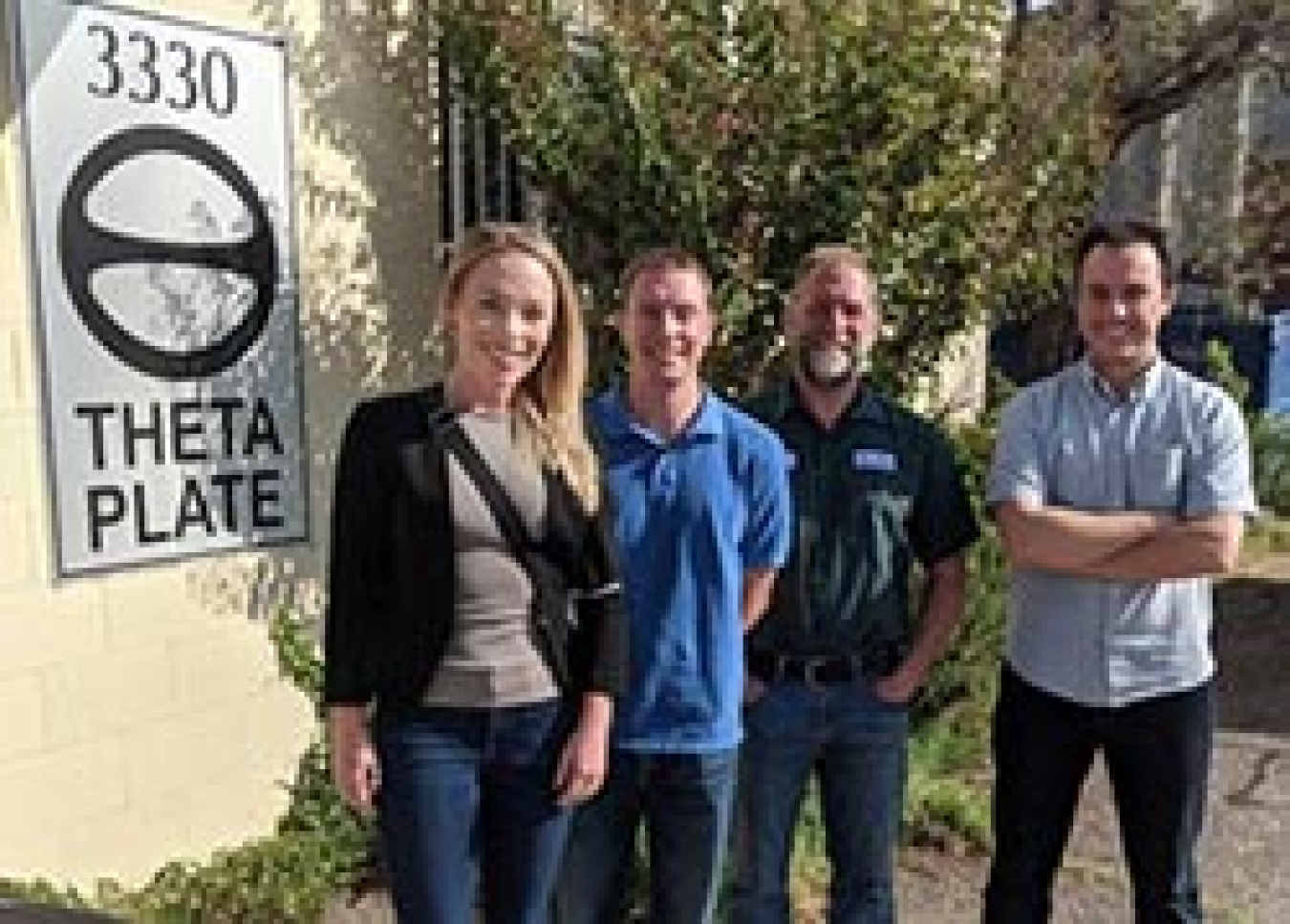 Four people smiling and standing outside