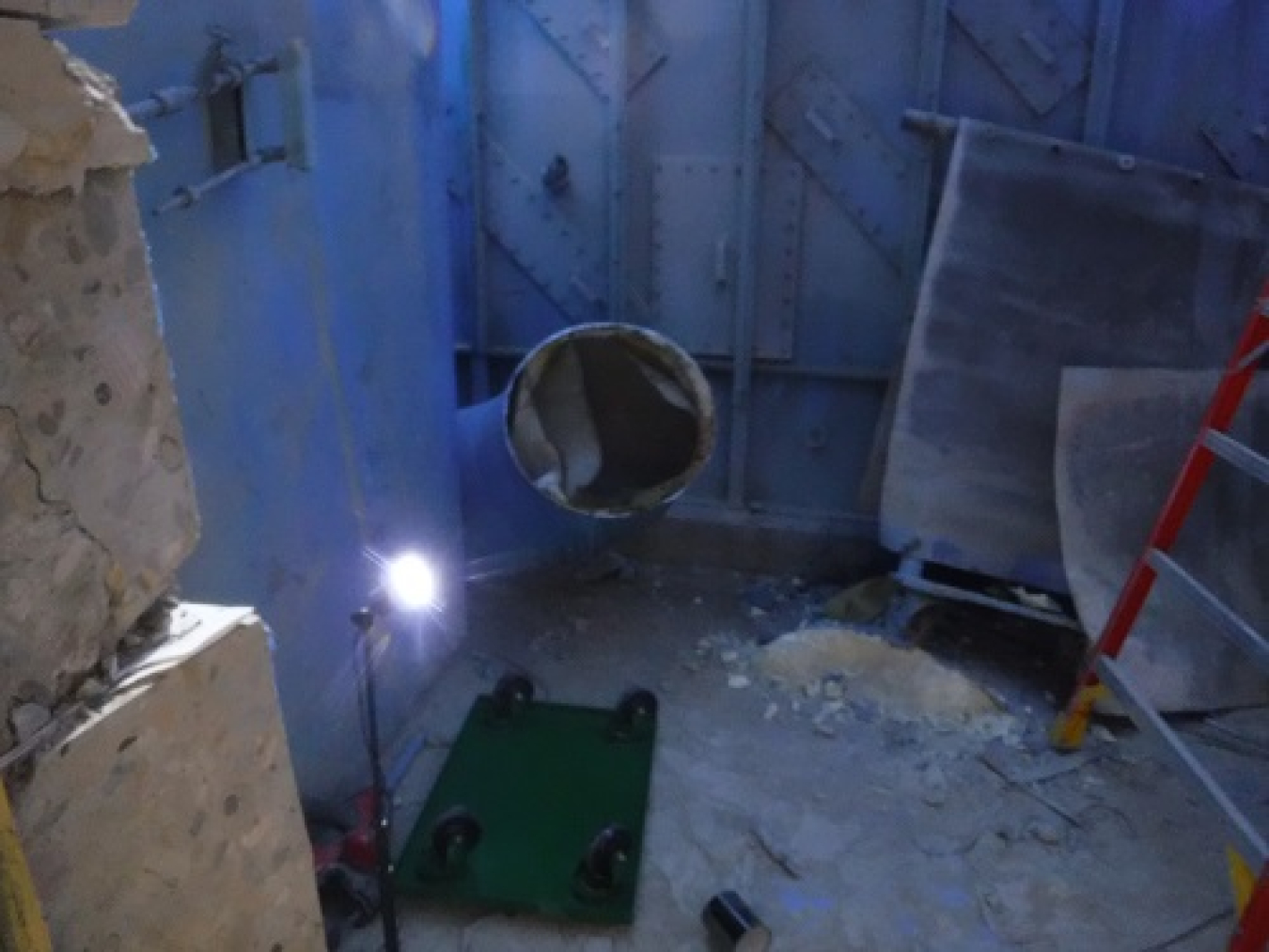 As part of deactivation activities inside the Vent Wash Room at the Main Plant Process Building, a section of a 26-inch ventilation duct, shown here prior to removal, was cut by a diamond wire saw. 