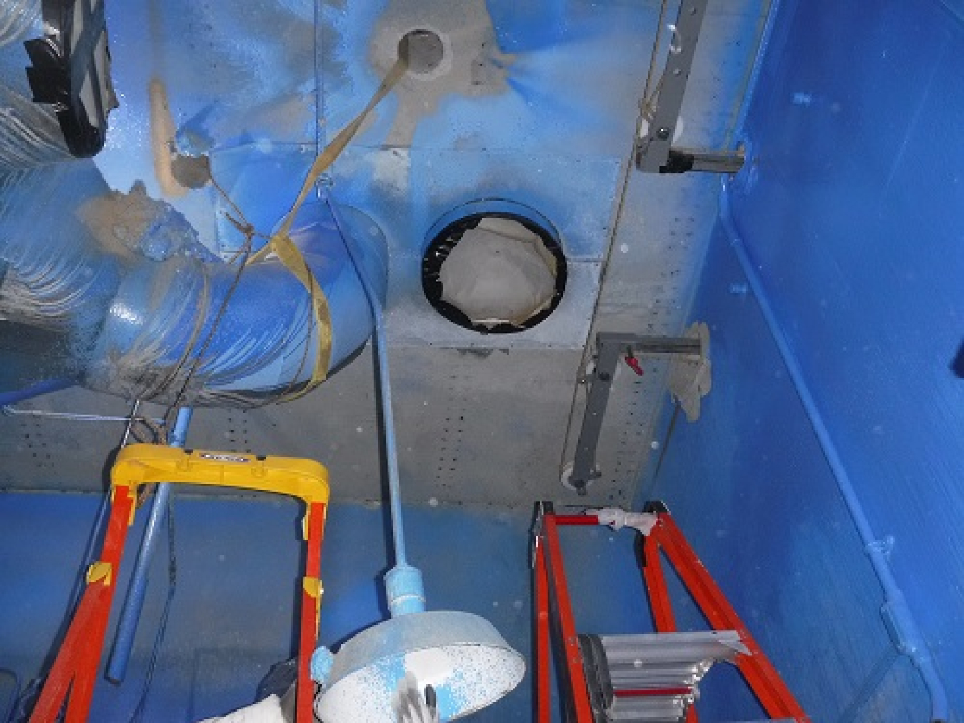 A section of a ventilation duct inside the Vent Wash Room at the Main Plant Process Building is shown before it was cut remotely with a diamond wire saw. The completed project involved 28 separate cuts to safely remove 19 sections of the duct.