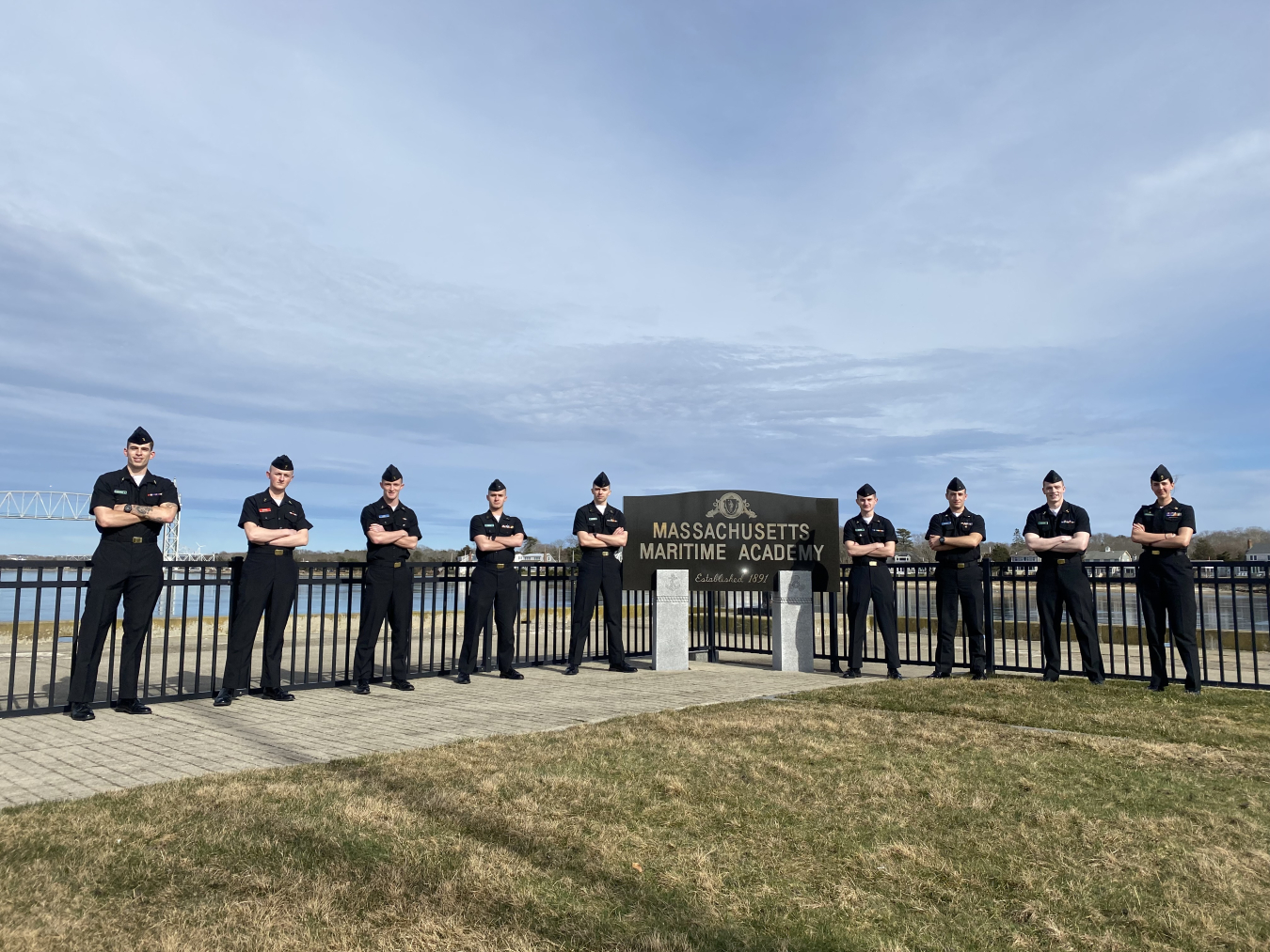 Massachusetts Maritime Academy team members stand on a pier.