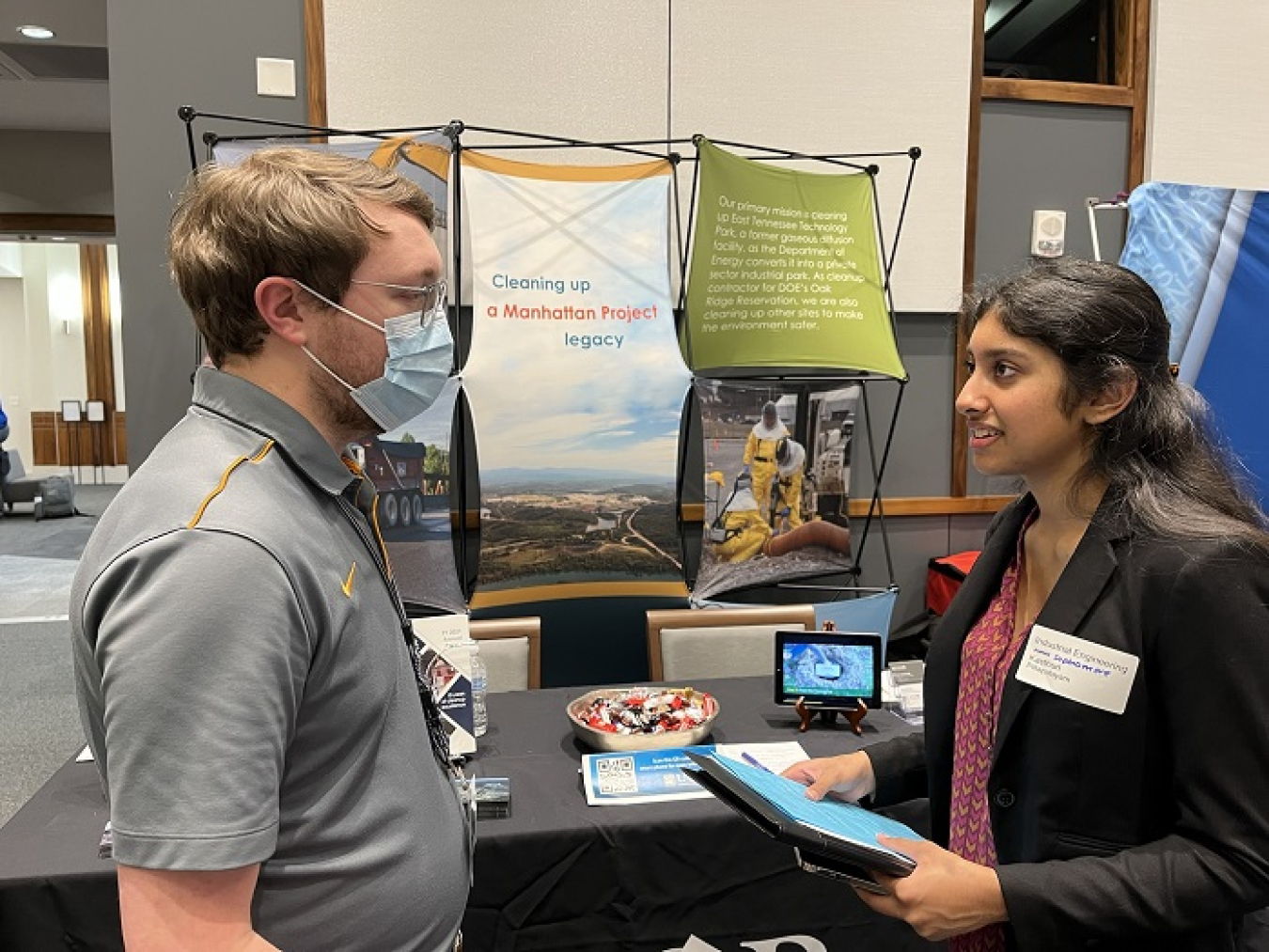 Derek Holstein, a new hire at UCOR, provides insight about engineering careers to Kasthuri Pillapalayam, a student attending the University of Tennessee’s Spring 2022 Engineering Expo.