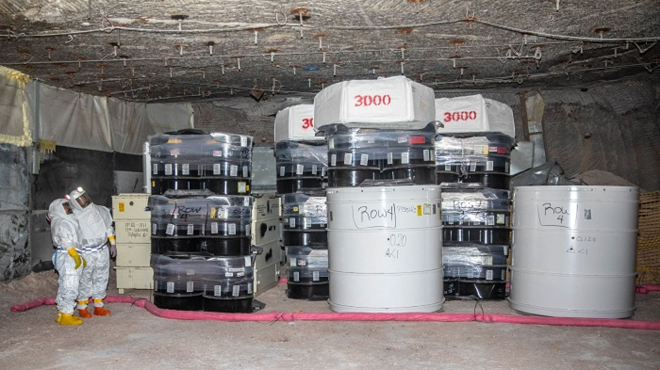 Underground waste handling personnel pause to view stacks of transuranic waste in Room 1, the last disposal cell to be filled before Panel 7 is completely full. Once Panel 7, Room 1 is filled, workers will begin emplacing waste in the newly mined disposal rooms of Panel 8.