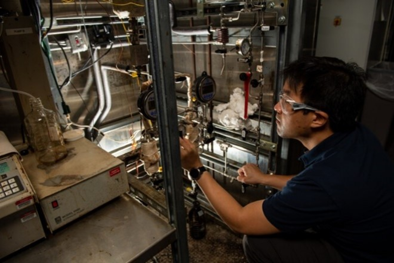 A PNNL researcher operates a bench-scale hydrotreater for co-processing study.