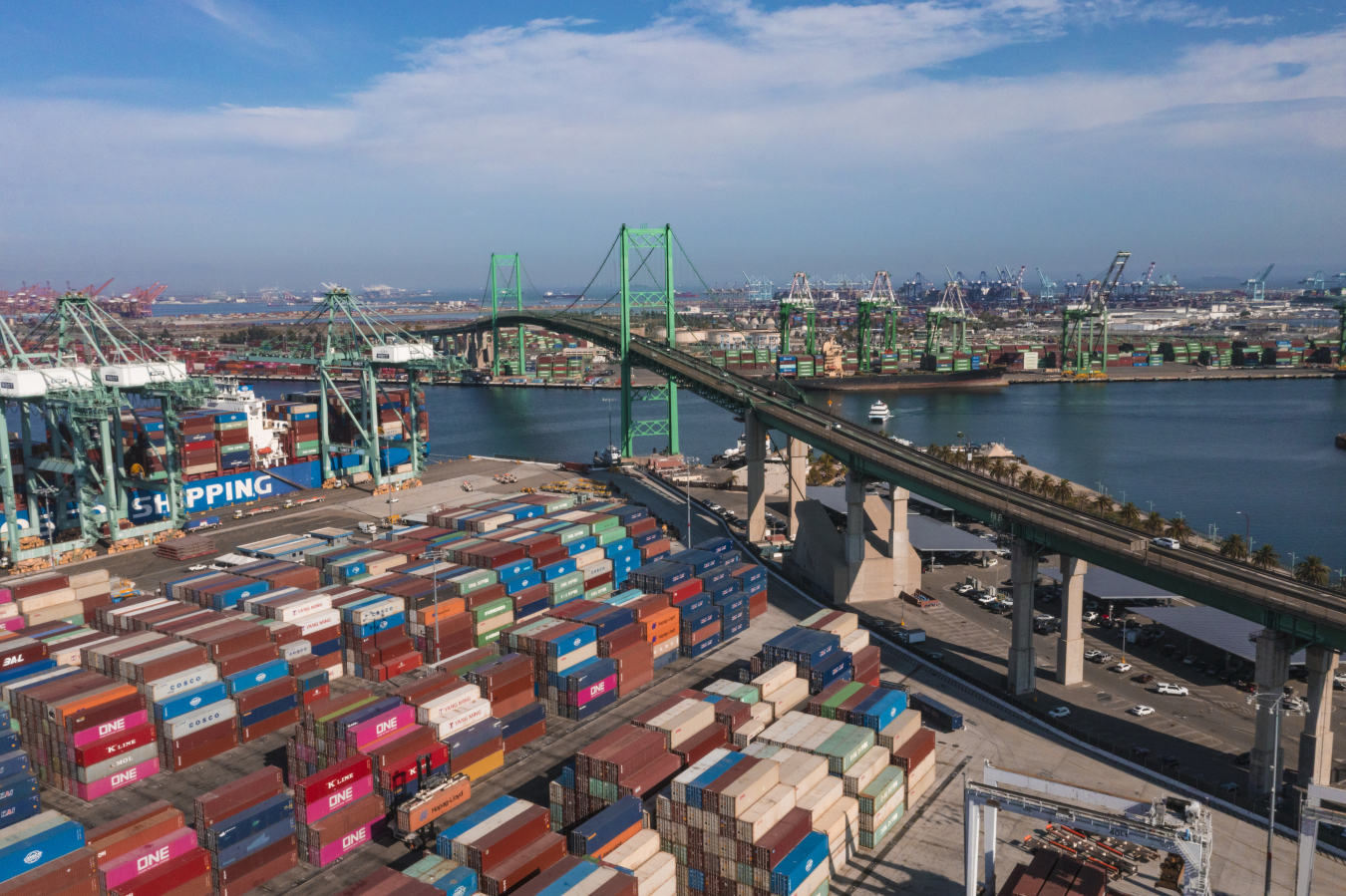 A birds-eye view of the Port of Los Angeles, which is loaded with numerous shipping containers of various colors.