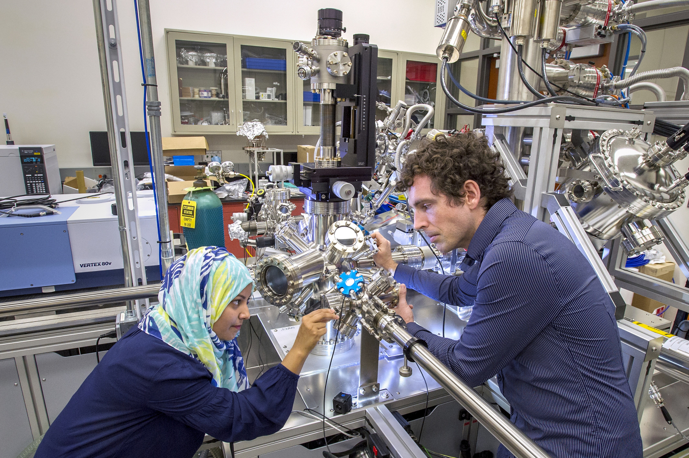 Scientists at the Center for Functional Nanomaterials at Brookhaven National Laboratory load a sample for in situ spectroscopy measurements. This state-of-the-art instrument allows for the study of chemical reactions at surfaces under elevated pressures through a combination of vibrational and photoelec¬tron spectroscopy. 