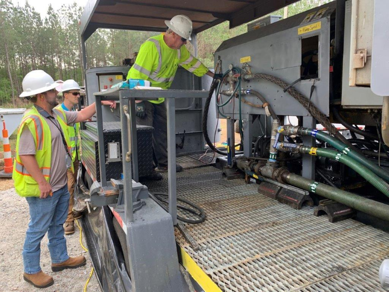 Savannah River Nuclear Solutions environmental engineers Bryce Garner, left, and Adam Willey ask questions of lead operator Daniel Ferrell, right, from field services contractor Cascade Environmental.