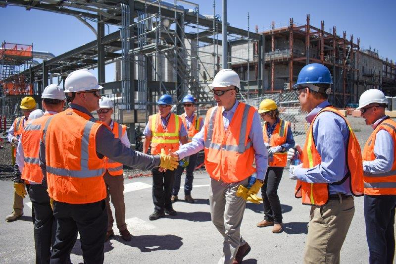 Deputy Energy Secretary David Turk, center, is greeted by Bob Wilkinson, president and general manager of Hanford Mission Integration Solutions, a site contractor, during a visit last week to the Hanford Site.