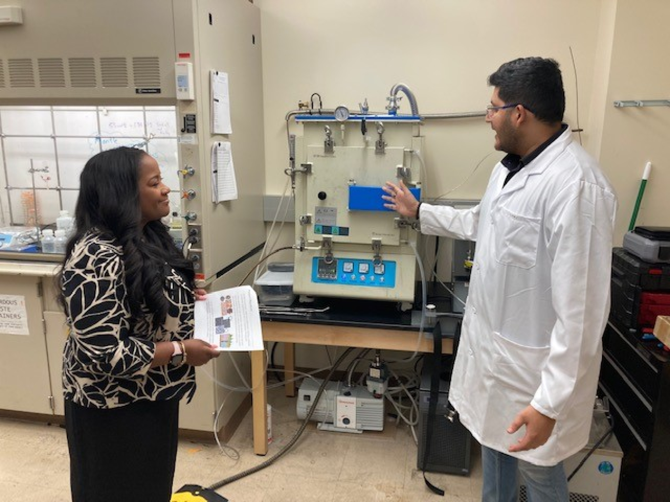 Doctoral student Suraj Pochampally explains to Nelson-Jean his research on eco-friendly materials for groundwater remediation.