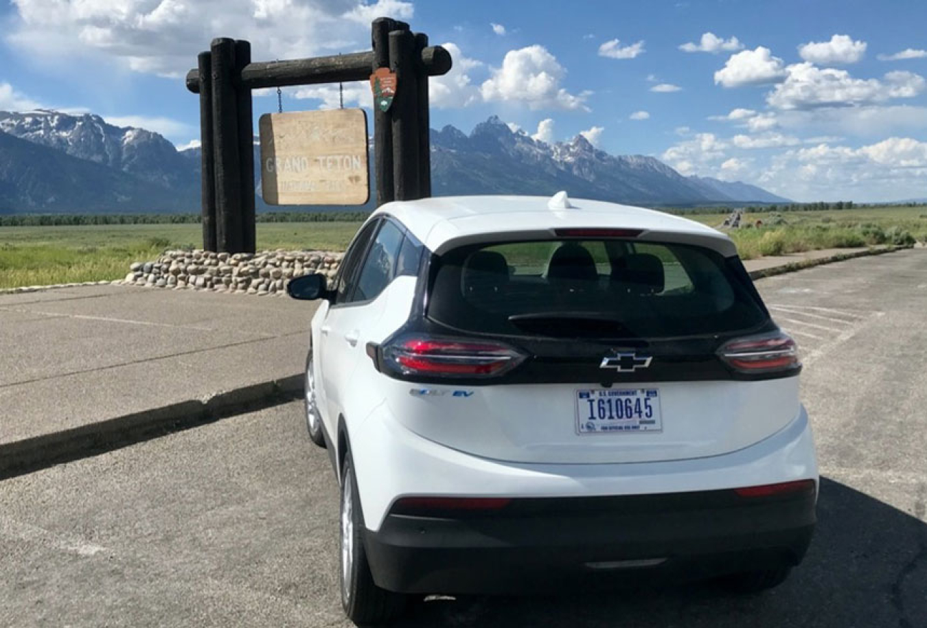 Electric vehicle parked in front of the Grand Tetons. 