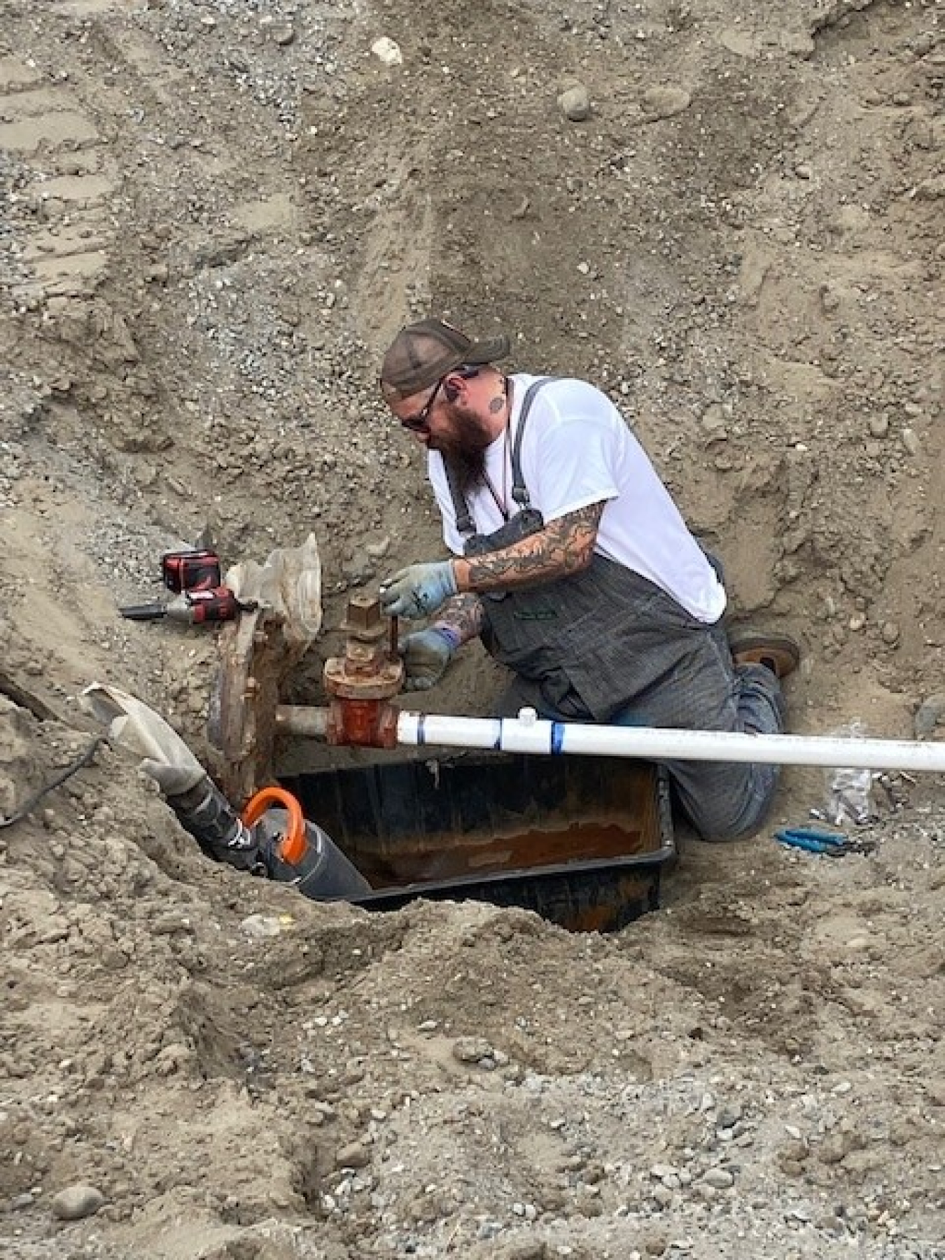 Nate Steel with Hanford Mission Integration Solutions disconnects water lines following completion of cleanup work at an area on the Hanford Site.