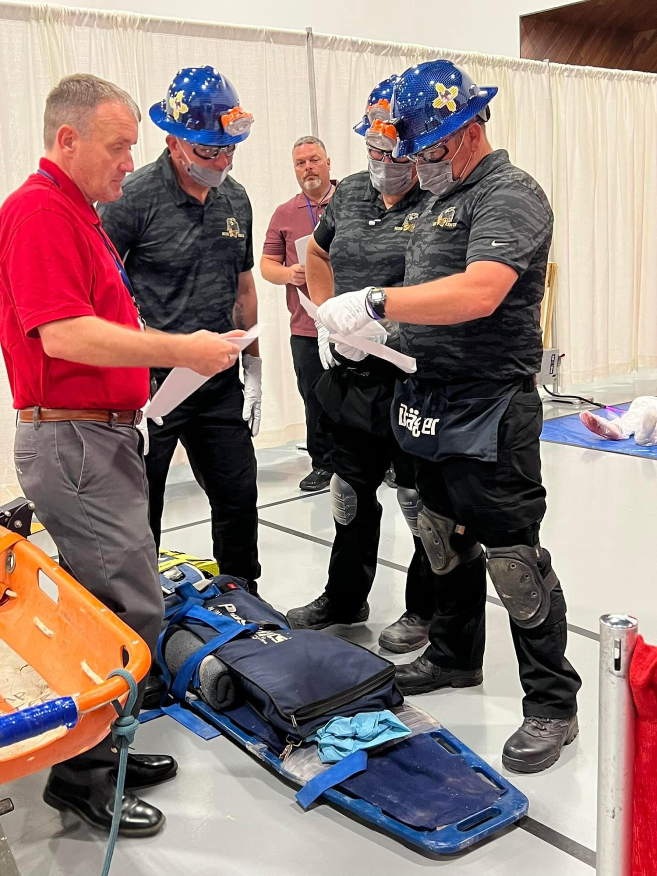 Members of the Waste Isolation Pilot Plant Red Mine Rescue Team prepare to administer first aid to a mock patient during a recent national mine rescue competition in Lexington, Kentucky.