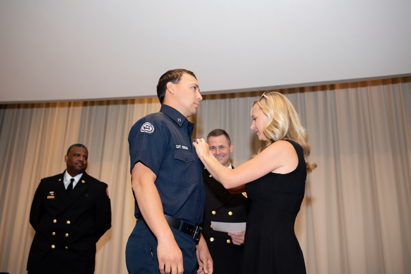 Capt. David Newman receives his promotional pin from his wife, Karen, during a ceremony held by the Hanford Fire Department recognizing individuals who received promotions between 2019 and 2022. 