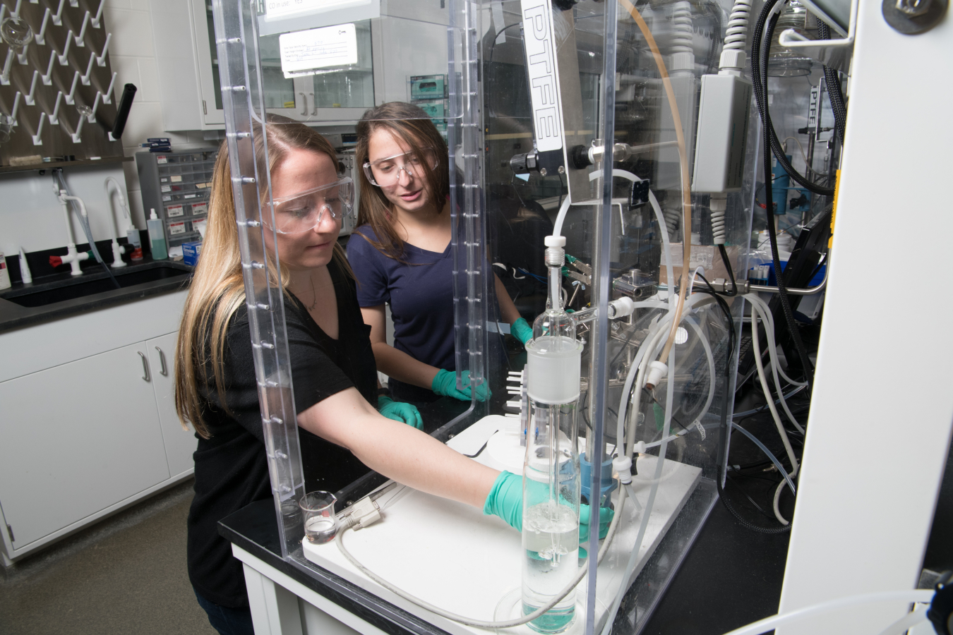 A scientist and engineer at the National Renewable Energy Laboratory collaborate as they test an electrochemical CO2 reduction cell