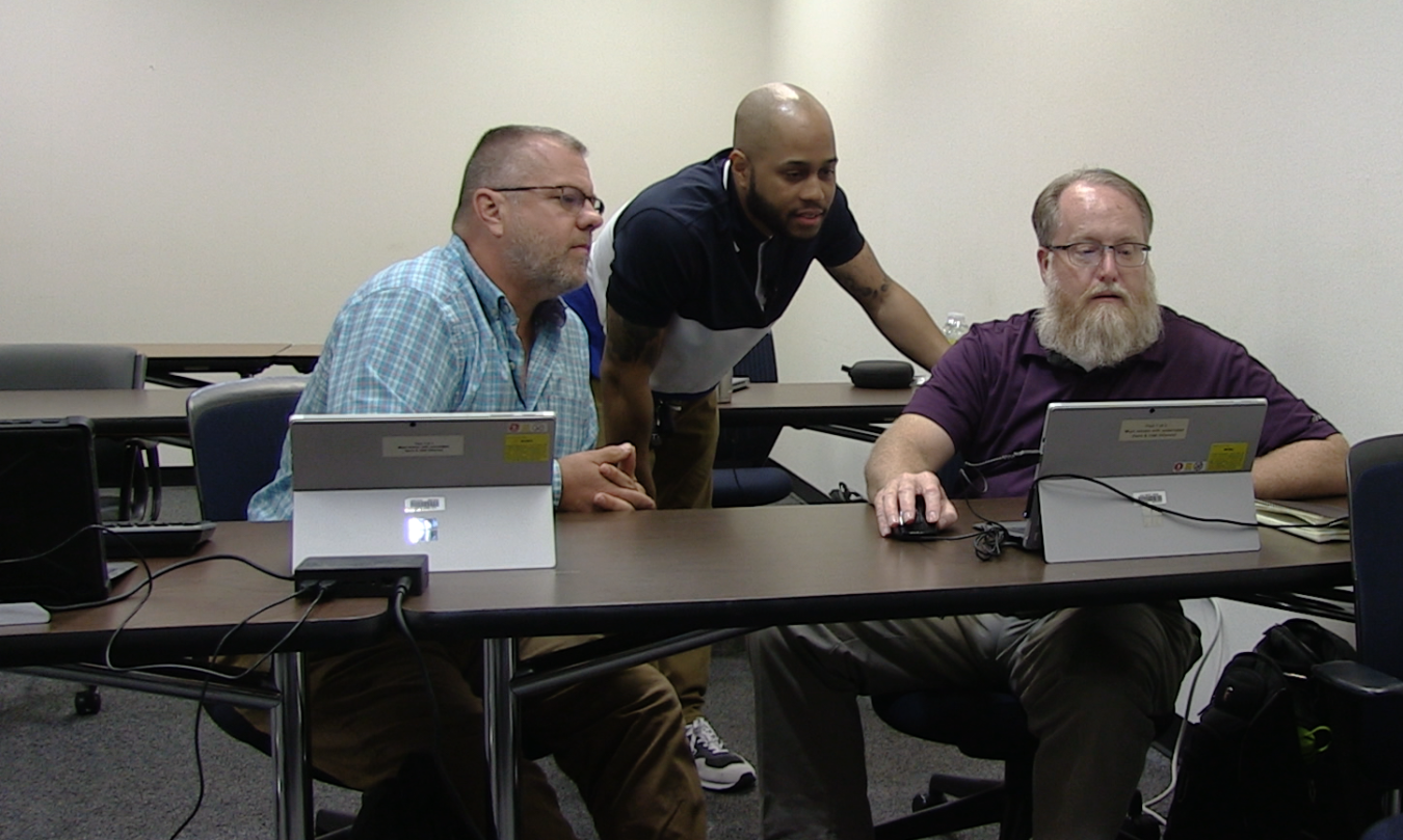 Savannah River Mission Completion (SRMC) Cybersecurity Analyst Christopher Walker, center, collaborates with SRMC cyber team members Jim Anderson, left, and Sean Nixon during an annual security assessment audit.