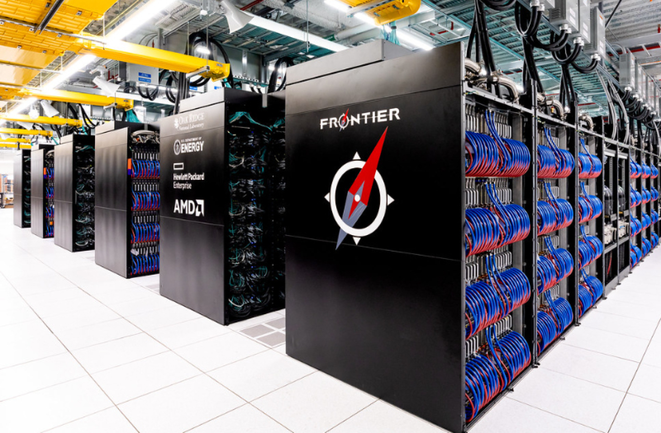 Photo of the Frontier supercomputer, with its name on the side and cabinets open so you can see the loops of blue and red wires.