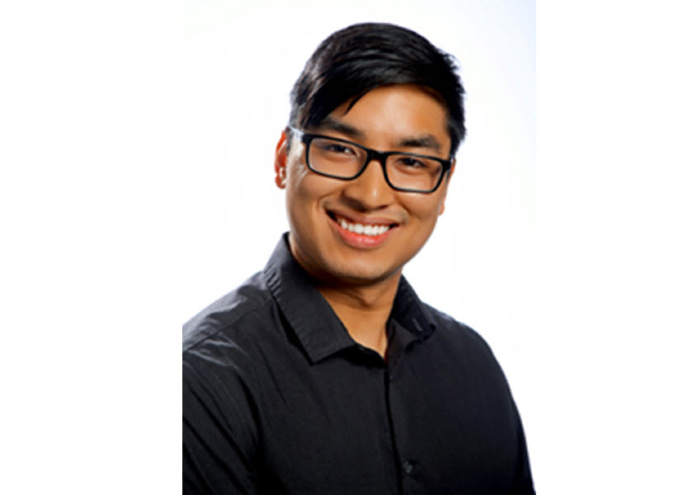 Headshot of a young man wearing glasses and a black button up shirt.