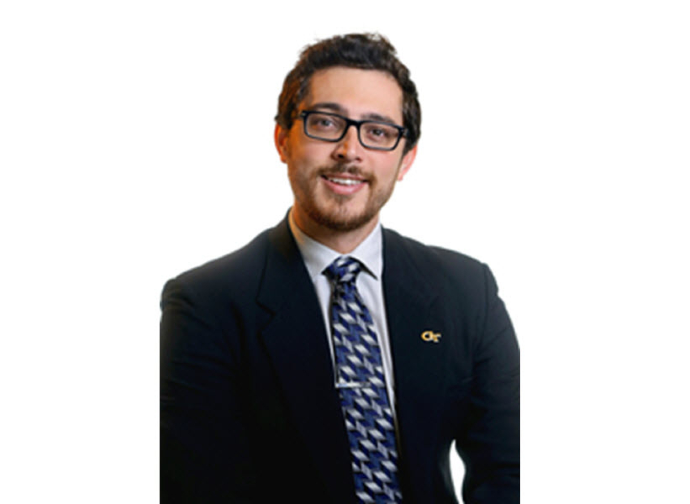 Headshot photo of a young man wearing glasses, black suit jacket, and blue patterned tie.