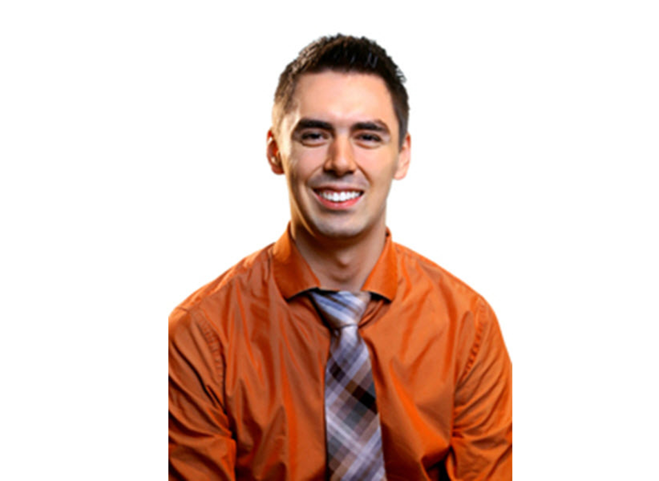 Headshot of a young man with a white background. He is wearing an orange button up shirt with a plaid tie and smiling warmly.