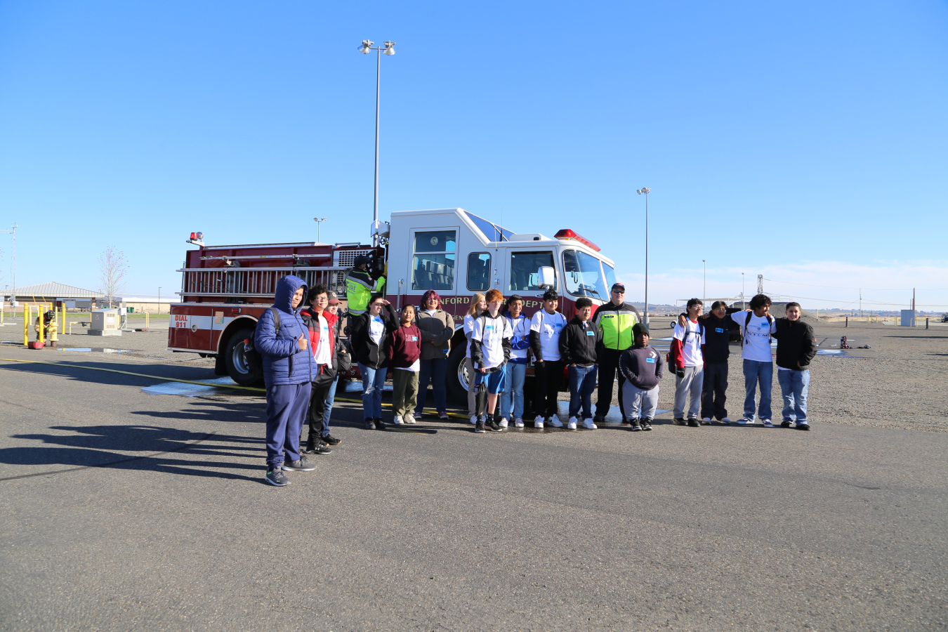 Students from Chiawana High School in Pasco, Washington stand alongside a Hanford Fire Department fire engine at the Volpentest HAMMER Federal Training Center, during STEM Day at the Hanford Site.