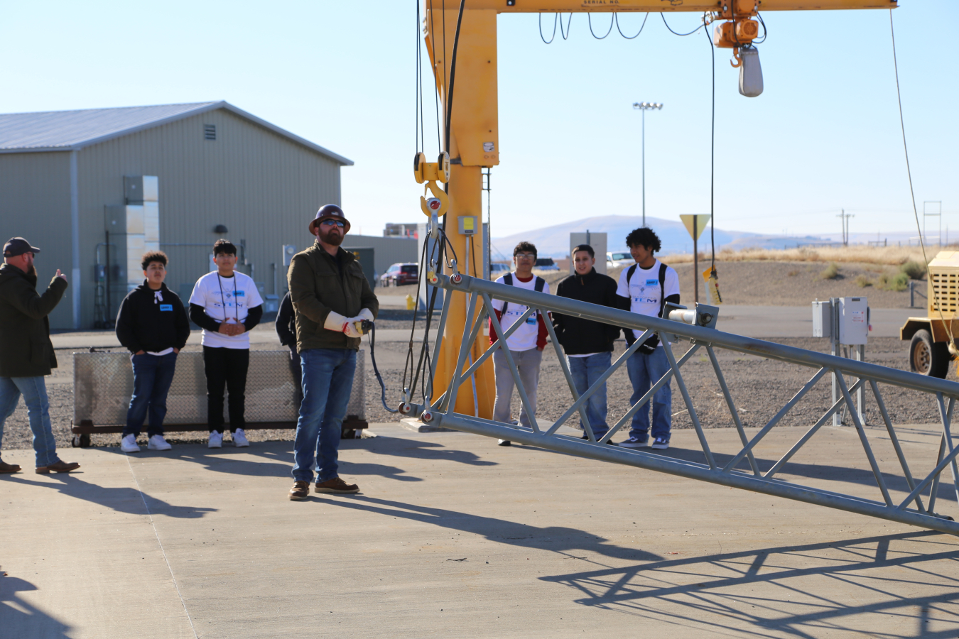 Tanner Hickman, center, and Ben Culver, far left, with Hanford Mission Integration Solutions demonstrate hoisting equipment used to train Hanford Site workers, highlighting various career opportunities for the next-generation workforce.