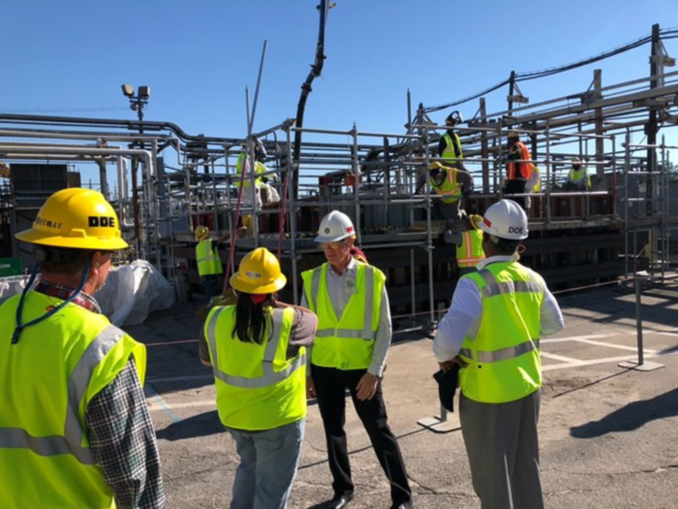 State regulators and officials with DOE-Savannah River (DOE-SR) and Savannah River Mission Completion gathered to observe the placing of concrete surrounding Diversion Box 6. DOE-SR Manager Michael Budney, center, discusses the work performed on Box 6, which is shown in the background. 