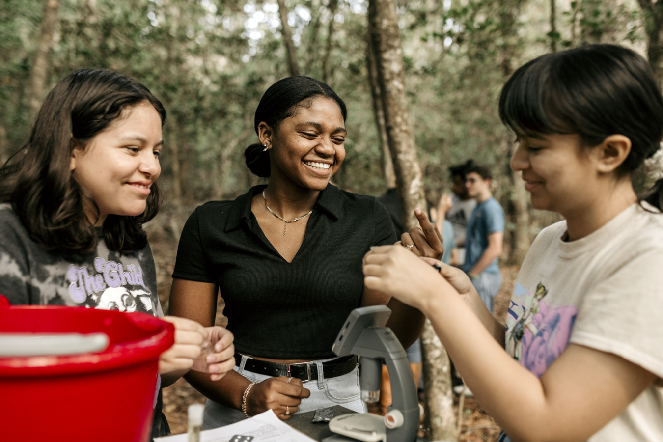 From left, South Aiken High School students Alexa Duran-Figueroa, Ashleigh Fair and Damaris Guillen examine aquatic organisms captured in a nearby streambed at Savannah River Site.