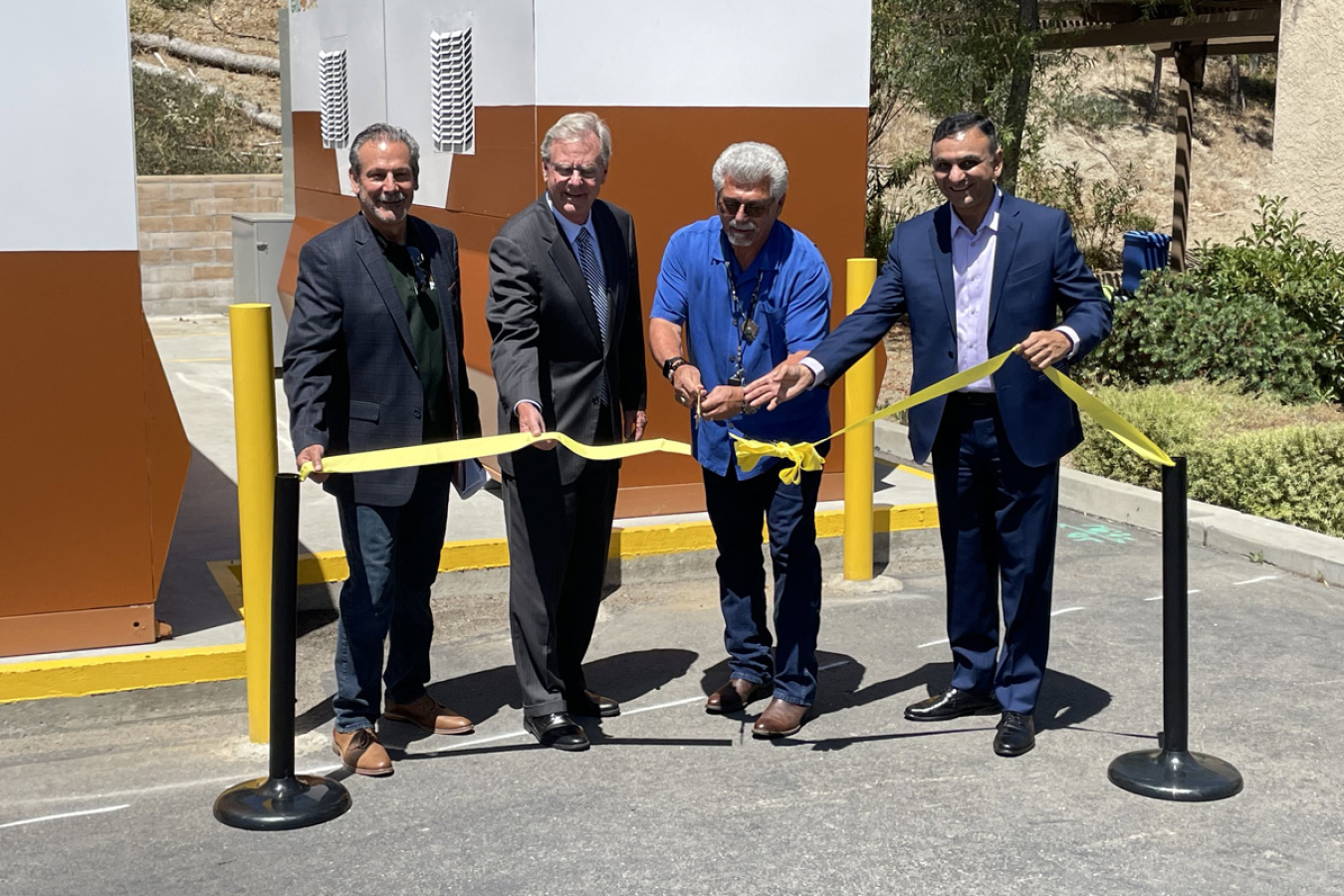 A ribbon cutting ceremony in front of an outdoor battery storage system.