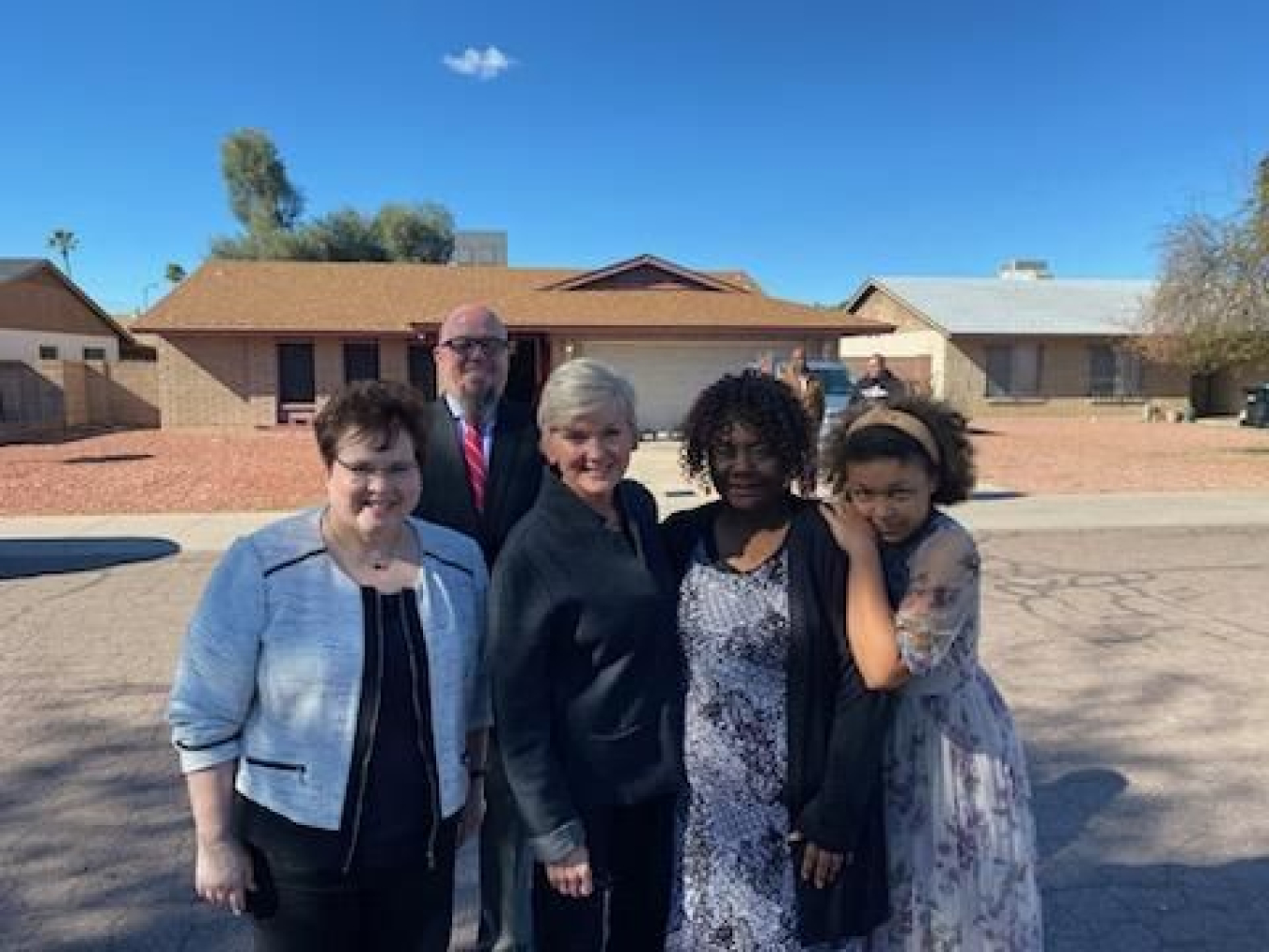 Secretary Granholm and Arizona Department of Housing staff visiting a recently weatherized residence with the homeowner.