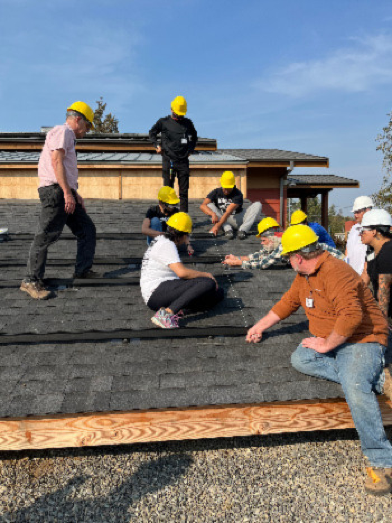 Community members install solar PV on a roof at Northwest Indian College