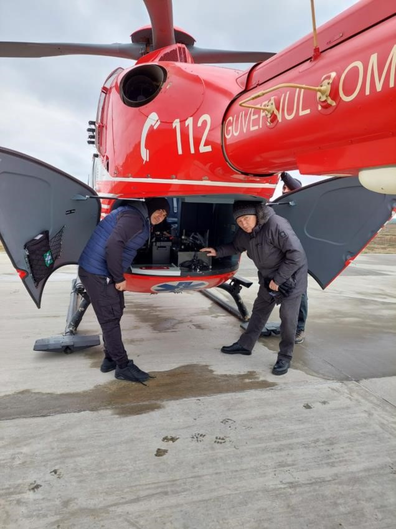 Two NNSA team members unload the back of a helicopter.