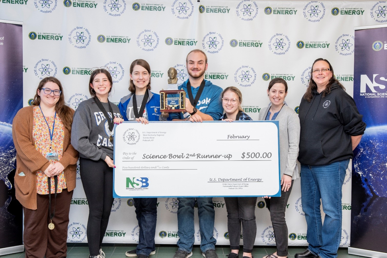 Graves County High School took third place in the DOE West Kentucky Regional Science Bowl. Pictured from left are Graves County High School coach Samantha Sims, Riley Ward, Lucy Baldwin, Jonathan Woods, Gracie Colley, Graves County High School coach Kait Crowe and EM Acting Paducah Site Lead April Ladd.