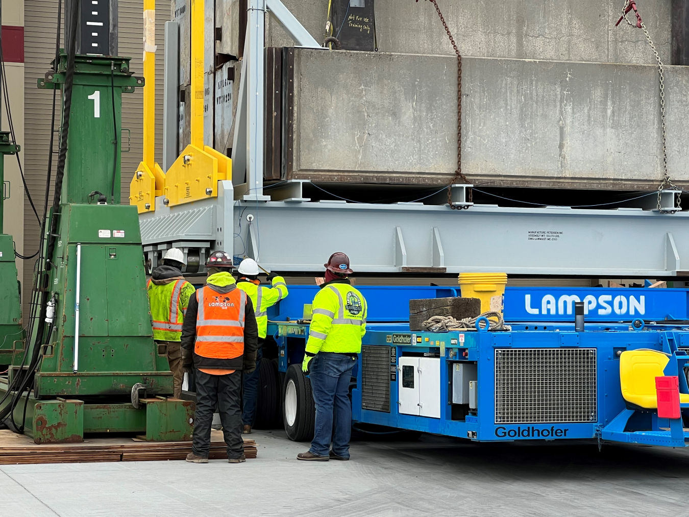 Crews measure the distance between a transporter and mock-up melter base during the successful crane test.