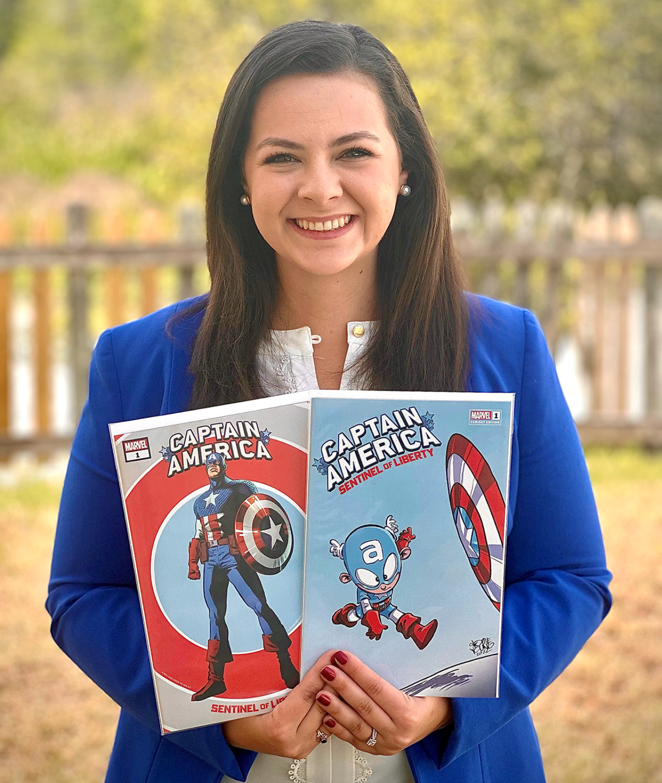 A portrait of Rebecca Cullen posing with two of her favorite Captain America comic books.