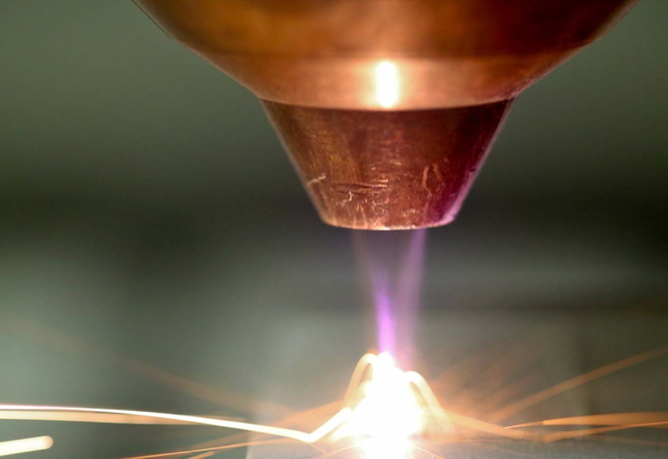 Close up image of a high-temperature concentrated flame that seems to be used to cut or weld.