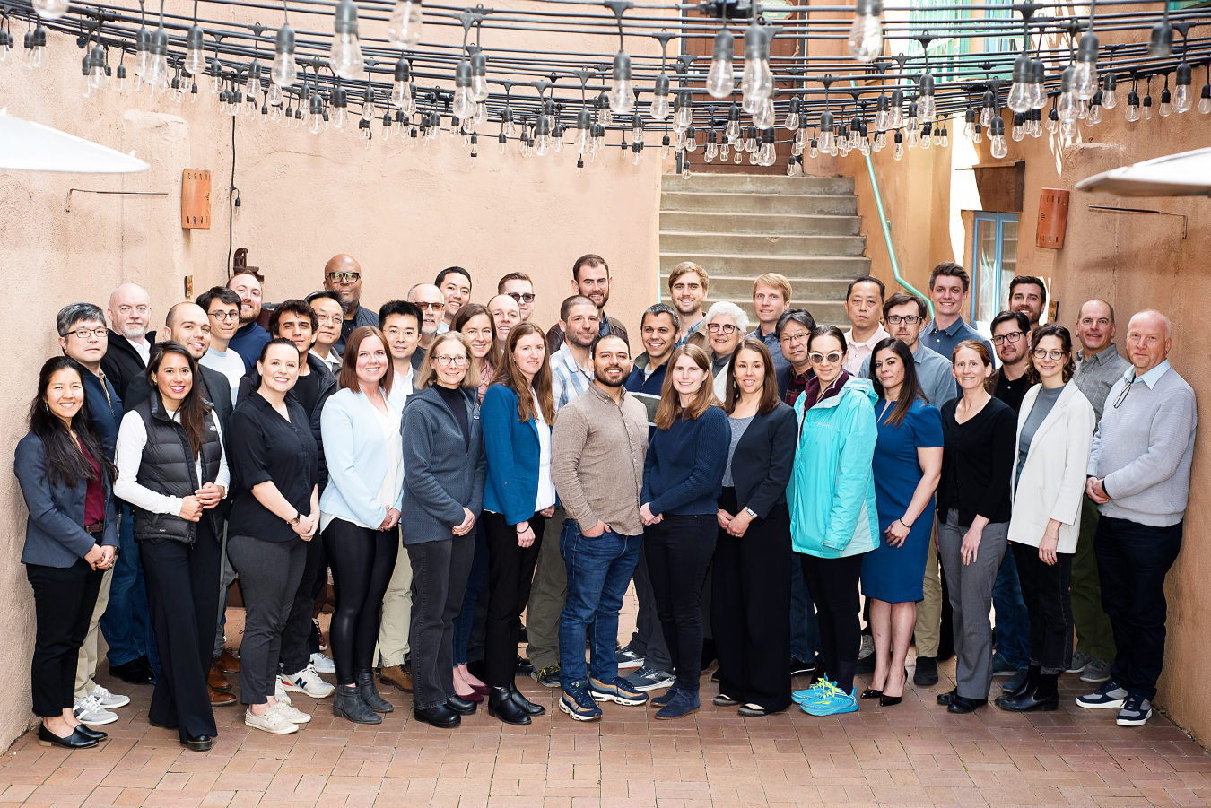 A group of 40 people pose for a photo in an outdoor patio.