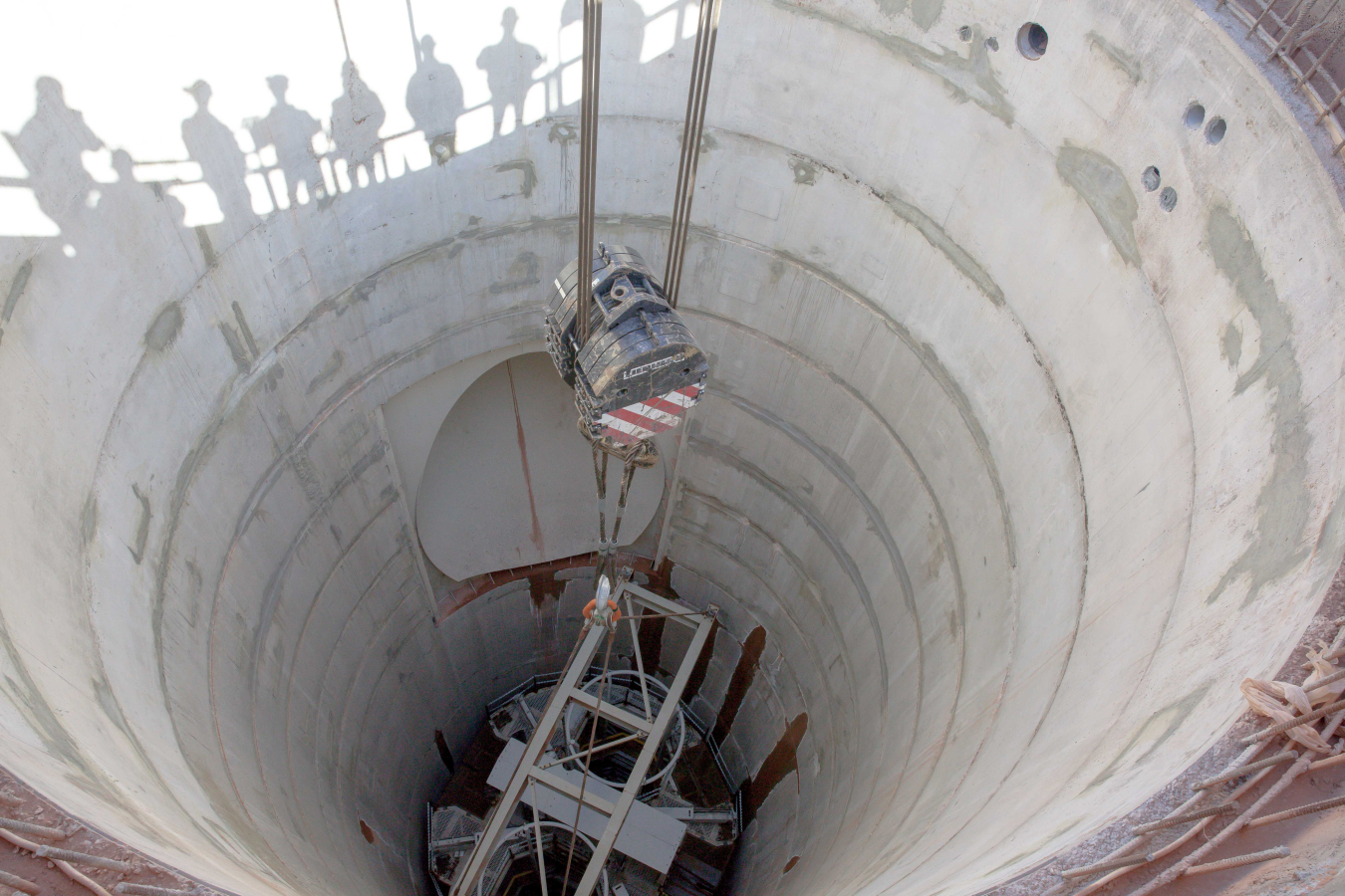 A three-tiered work stage known as the Galloway is lowered into the utility shaft at EM's Waste Isolation Pilot Plant.