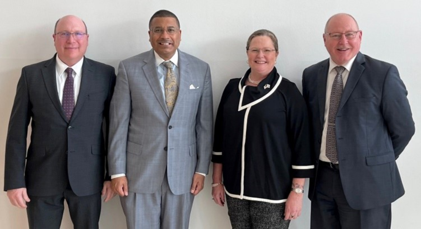 Three men and a woman pose for a photo.