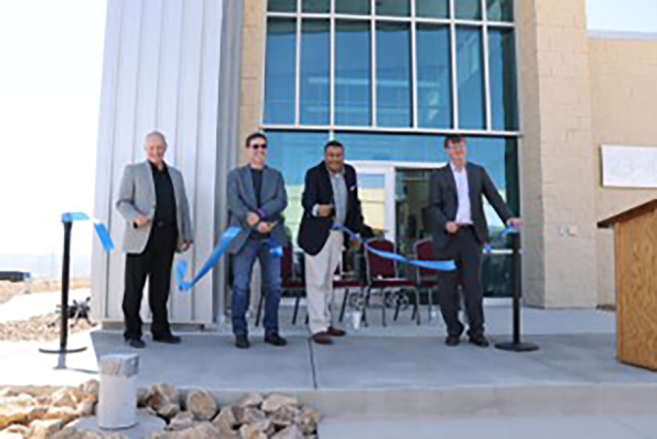 Frank Rose and three Nevada National Security Site and NNSA leaders cut a ribbon in front of a building.