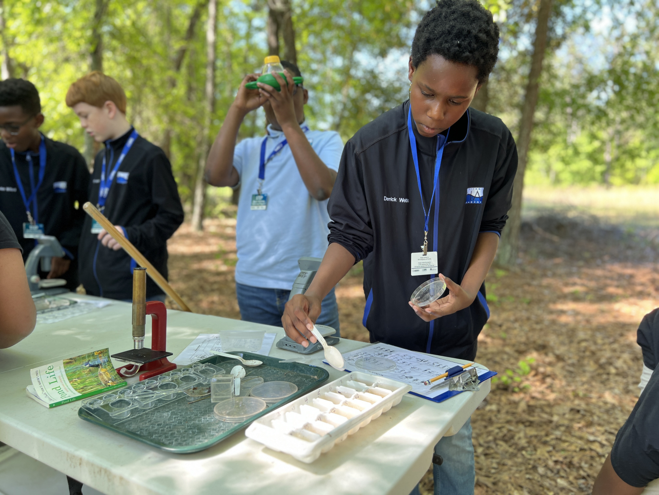 Heritage Academy student Derek Webb uses a dichotomist key to identify an aquatic specimen caught in a Savannah River Site streambed. 